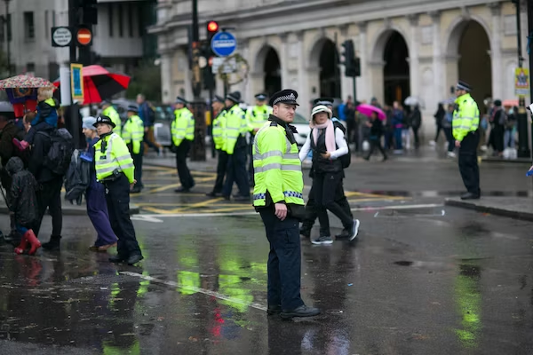 police officers wearing neon jackets while monitoring the crowd on a busy street