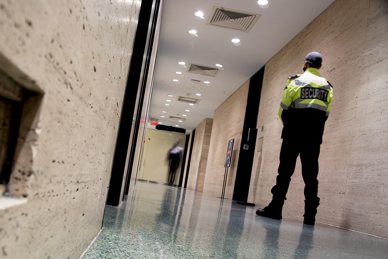A security guard monitoring a corridor 