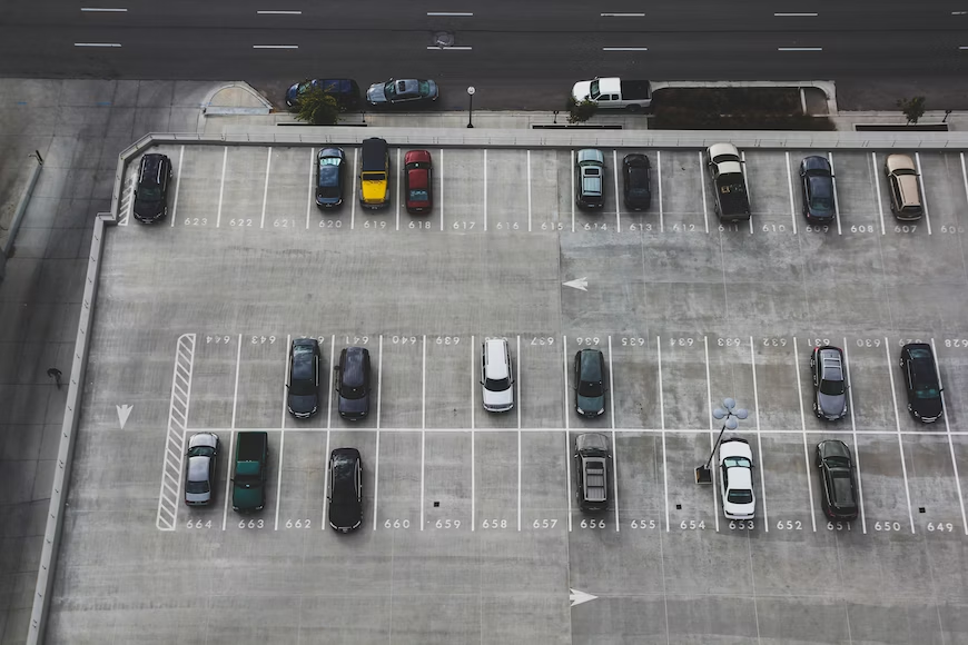 Top shot of cars parked in an open parking lot 